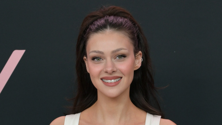 Nicola Peltz smiling for a photo on the red carpet