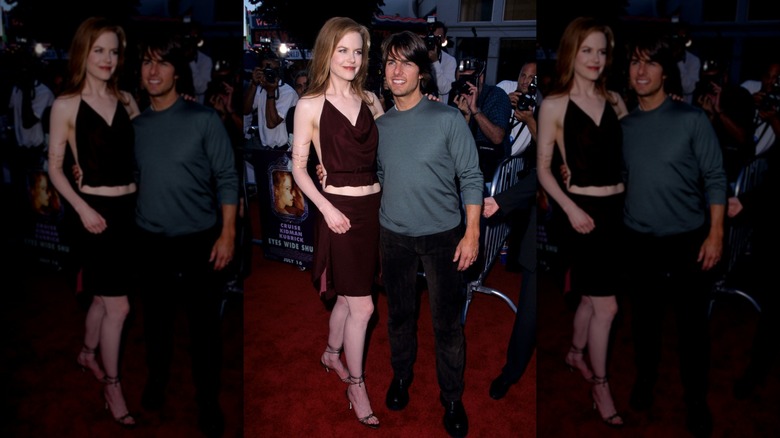 Nicole Kidman in a burgundy two-piece on the red carpet with Tom Cruise in 1999