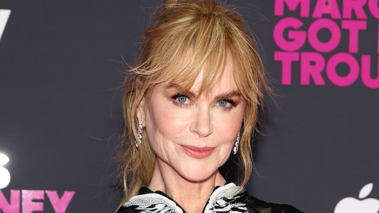 Nicole Kidman smiling on the red carpet in front of a black background