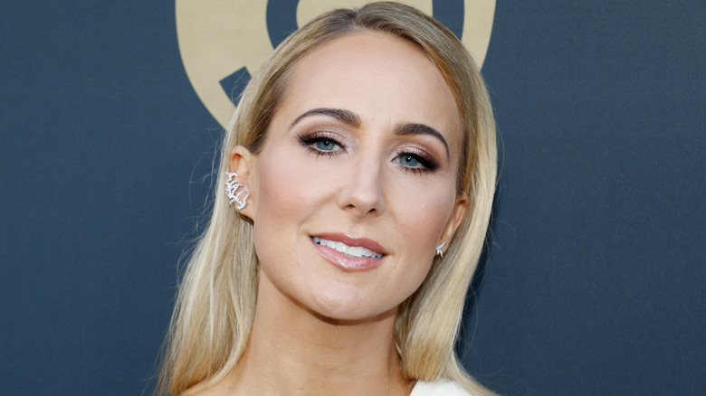 Nikki Glaser on the red carpet in a white one-shouldered gown