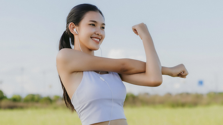 woman smiling while stretching her arms