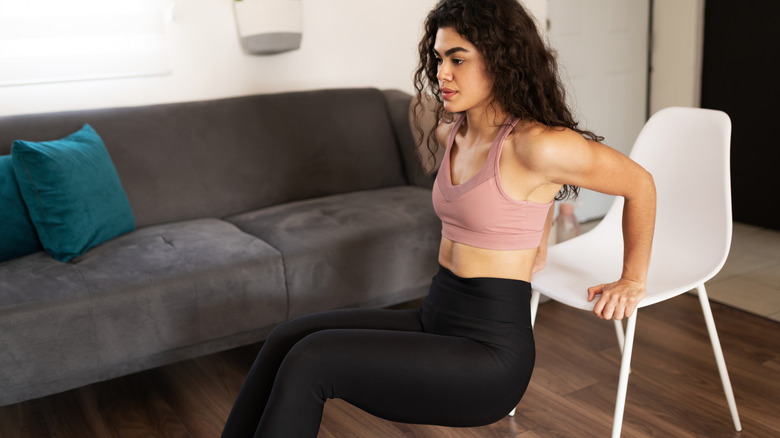 woman doing tricep dips with chair