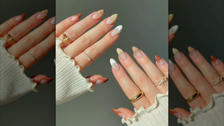 Two hands showing biege and brown French tips adorned with 3D bows in matching shades