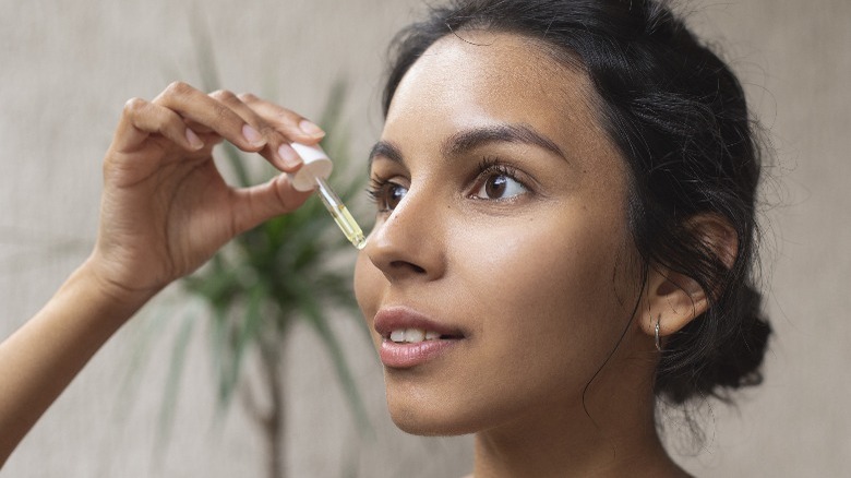Woman applying oil serum