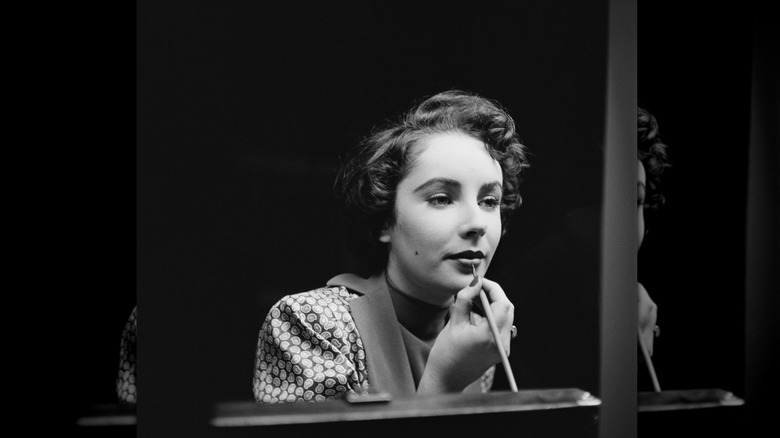 Elizabeth Taylor pictured applying her lipstick in 1948