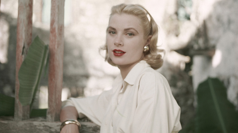 Grace Kelly with red lipstick outside in a garden