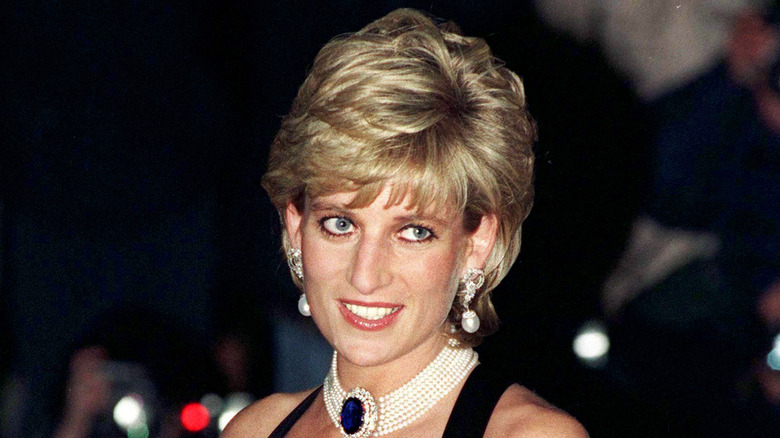 Princess Diana smiling with short hair and a pearl choker