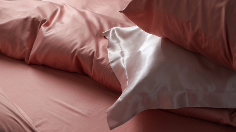 Silk pillowcases stacked on silk sheets