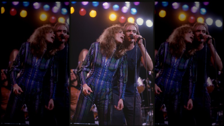 Carly Simon wearing a plaid jumpsuit on stage