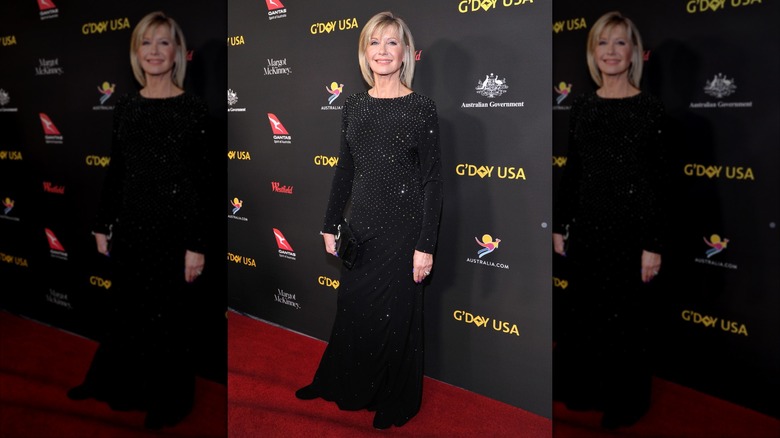 Olivia Newton-John on the red carpet in 2018 in a rhinestone, long black dress