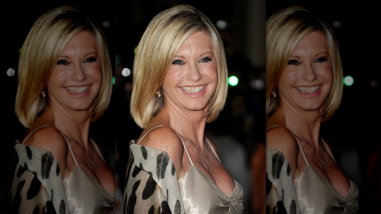 Olivia Newton-John smiling over her shoulder with her hair cut into a bob in 2010