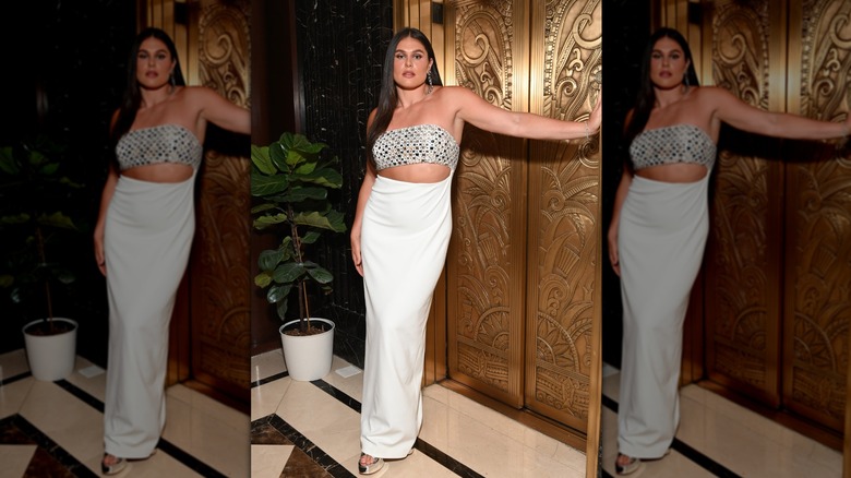 Ilona Maher leaning in front of an ornate elevator while wearing a gown with a sparkly bandeau-style bodice