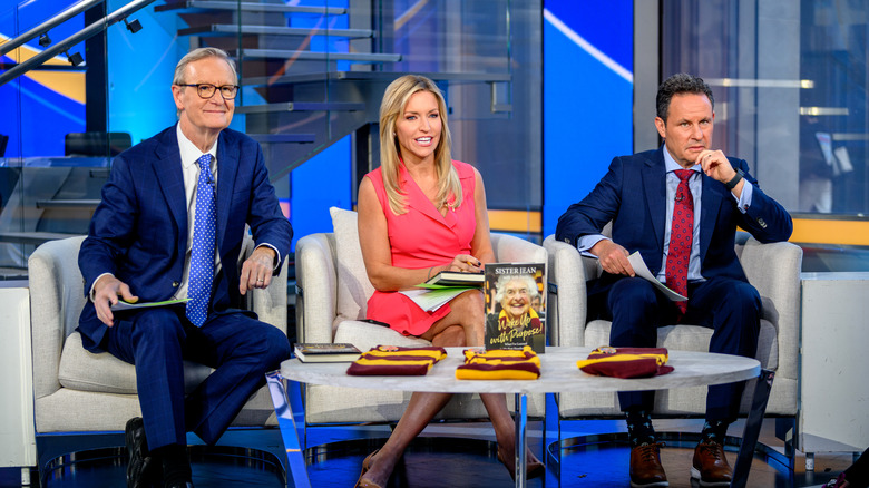 Hosts Steve Doocy, Ainsley Earhardt and Brian Kilmeade as Jean Dolores Schmidt, also known as Sister Jean, visits "Fox & Friends" at Fox News Studios on March 07, 2023