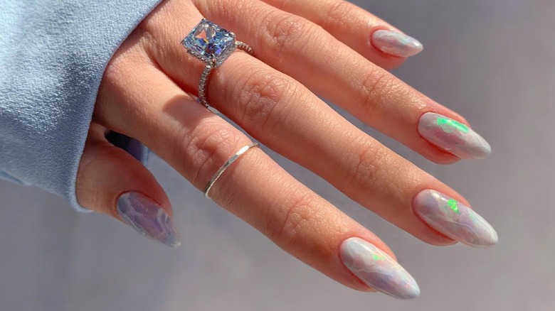Close-up of hand with sparkly, opal nails