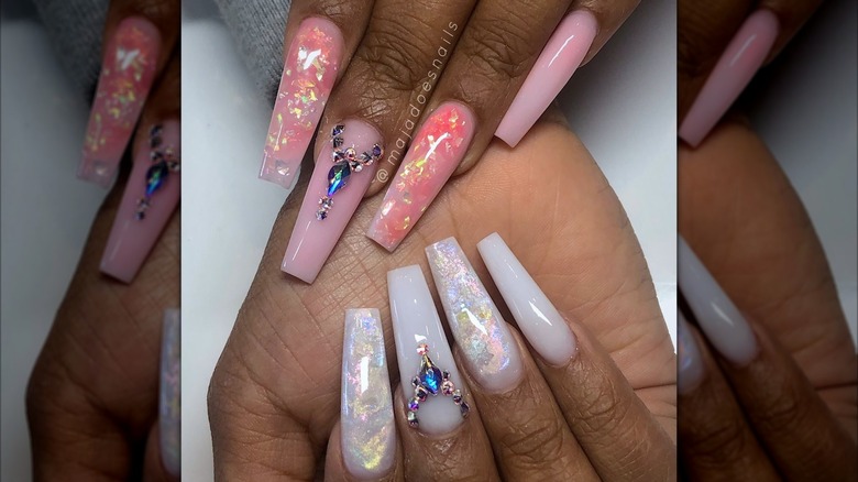 Two hands showing a white and pink nail design, each with accent opal nails
