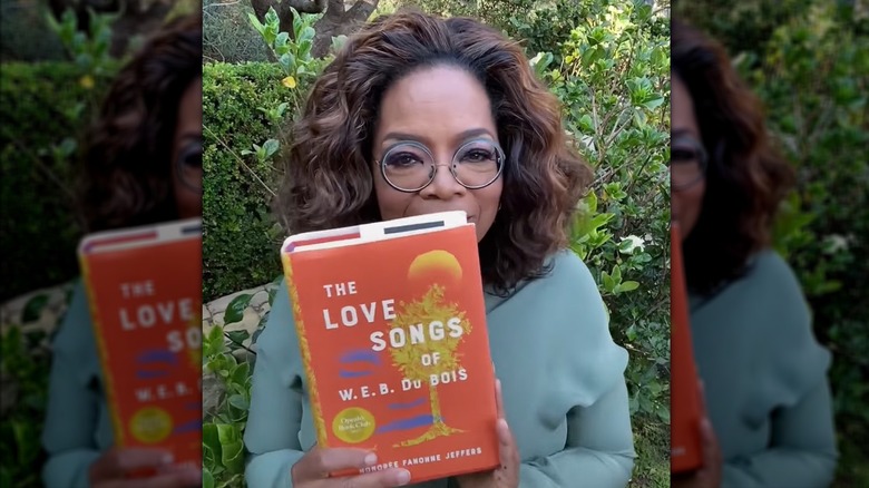 Oprah Winfrey holding a copy of The Love Songs of W.E.B. Du Bois by Honorée Fanonne Jeffers