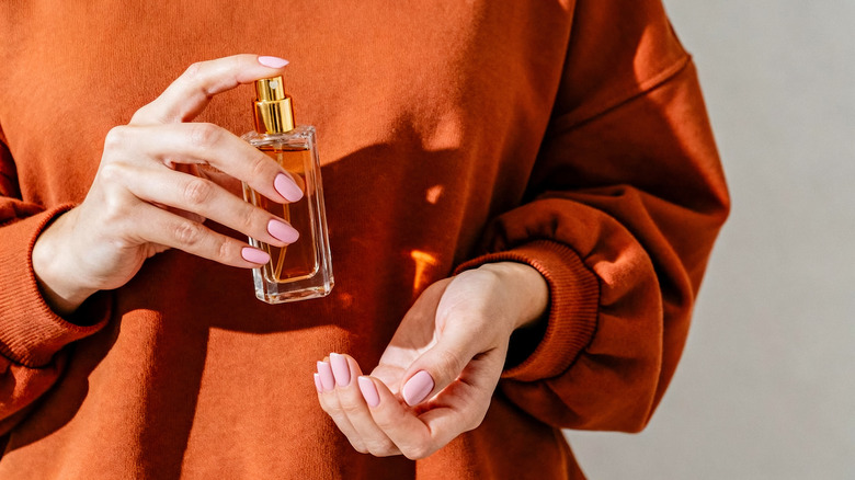 A woman spraying perfume on her wrist