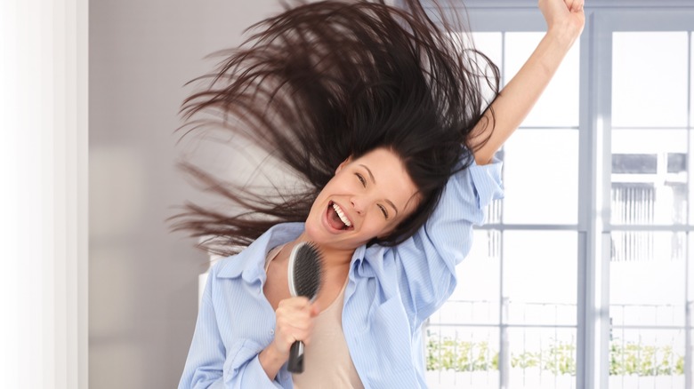 Woman singing into a brush