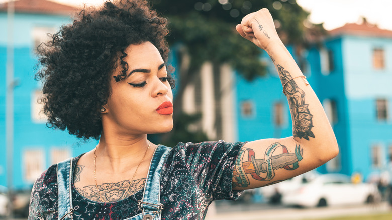 woman applying cream to tattoo