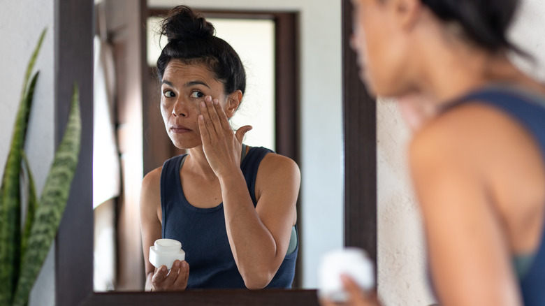 Woman applying moisturizer