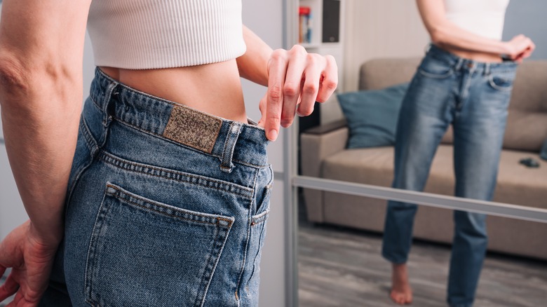 Woman wearing too big jeans