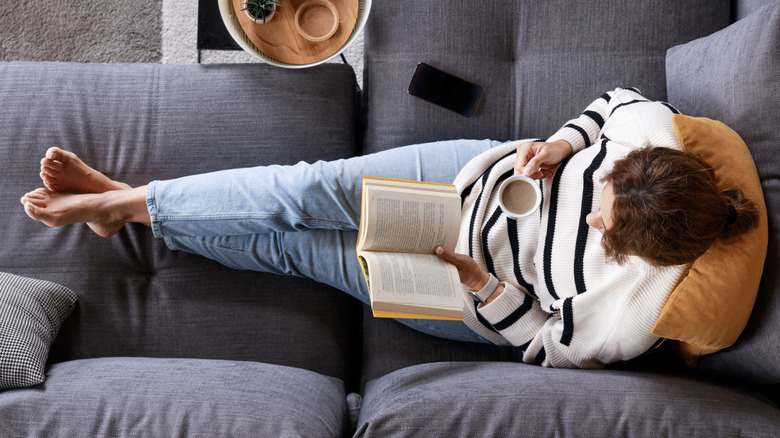 Woman on couch reading book