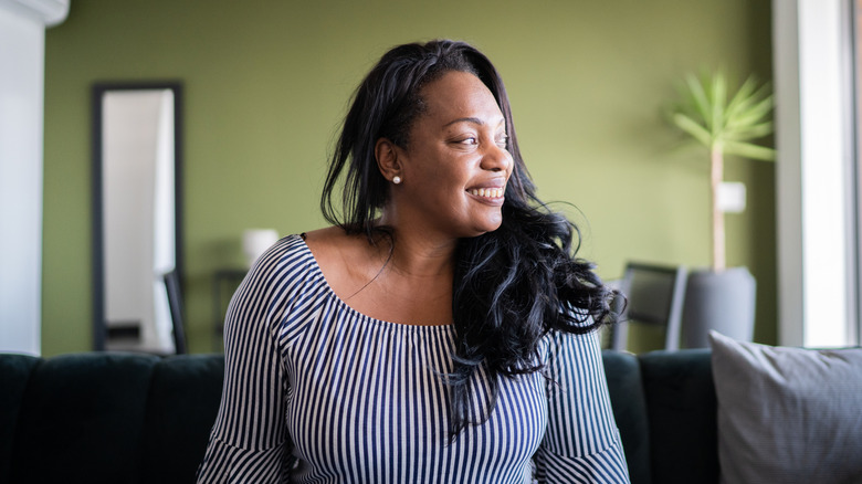 Woman happy in a green room looking to the side