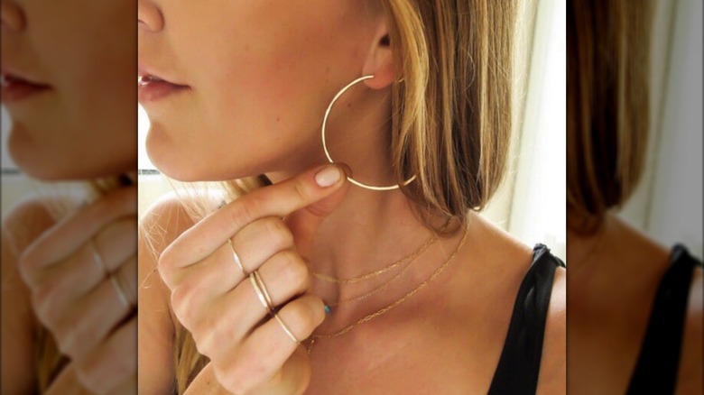 A close up of a thin golden hoop in a woman's ear