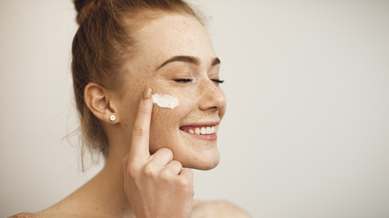 Woman applying moisturizer
