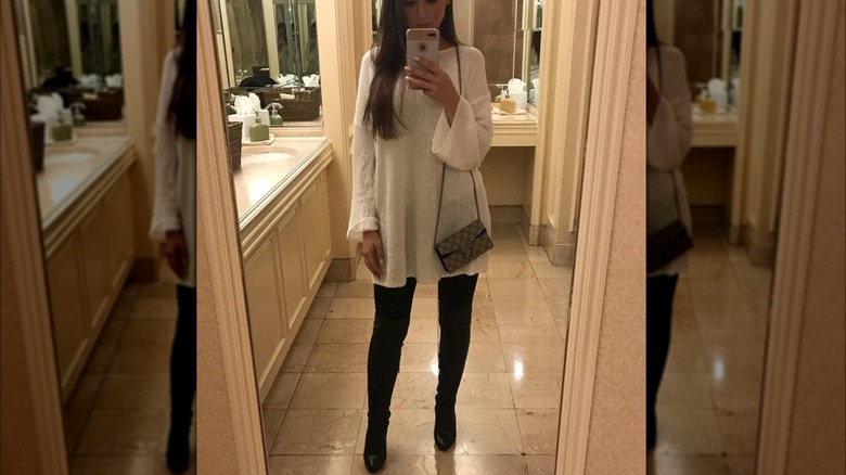 A woman on Instagram taking a selfie with over the knee boots