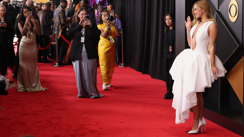 Photographers taking pictures of Addison Rae posing on Grammy Awards red carpet in 2026