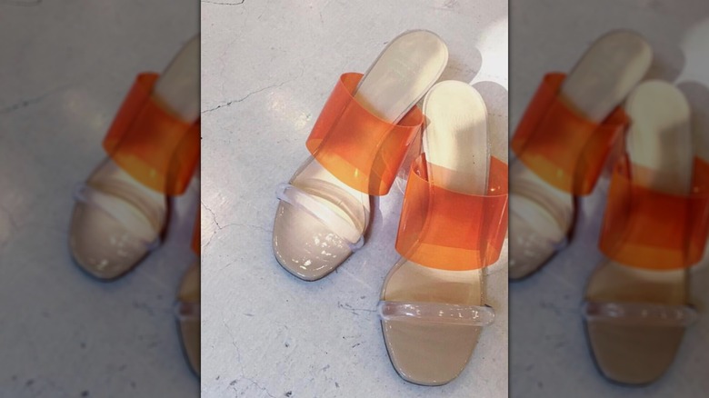 A pair of wedge heels with orange and clear vinyl straps