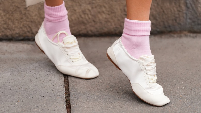 A woman wearing sneakerina shoes with pink socks