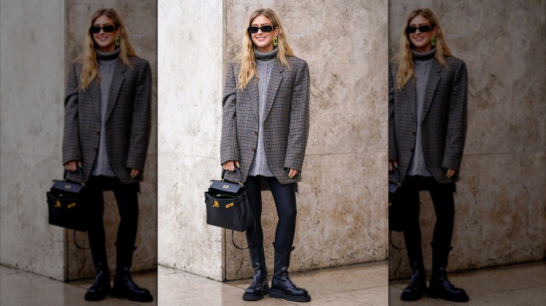 A woman in a grey blazer and chunky boots