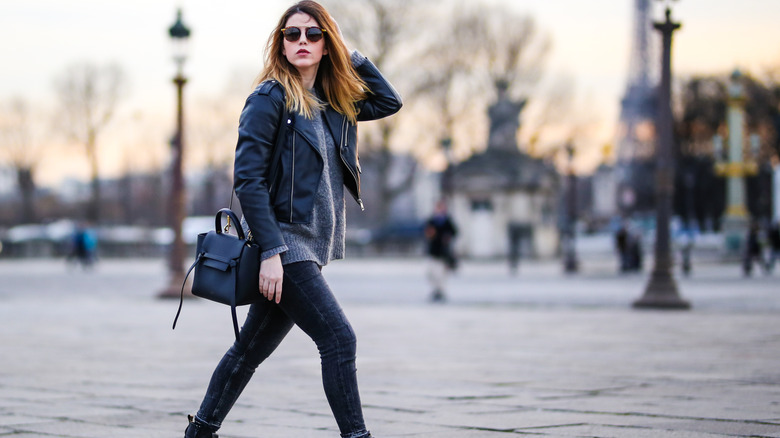 A woman wearing leggings and a leather jacket