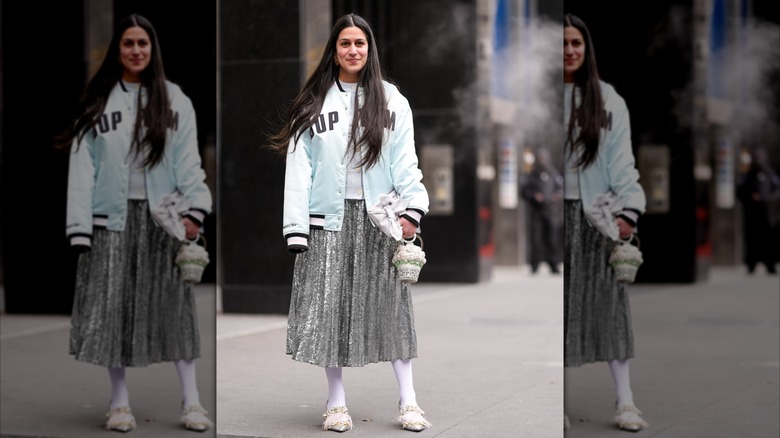 A woman in a satin accordion midi skirt