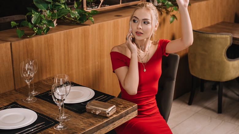 A woman in a red bodycon dress at a restaurant