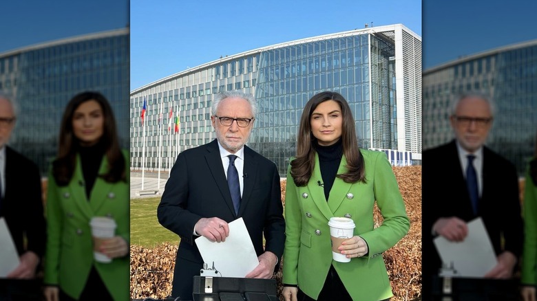 Kaitlan Collins and Wolf Blitzer standing side-by-side together outside in March 2022
