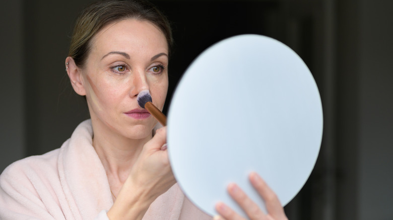 Women applying contour and blush to her face