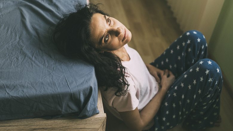 woman sitting on bedroom floor