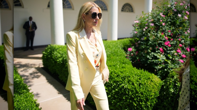 Pam Bondi wearing a yellow suit with a floral top