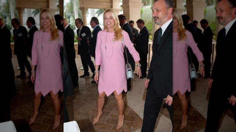 Pam Bondi at an event in a pink dress with a pointy hemline and tan shoes