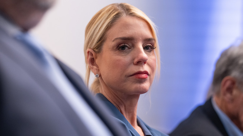 Pam Bondi looks at a camera during a press briefing in 2026