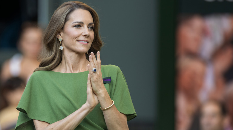 Kate Middleton clapping her hands in a green dress at Wimbledon