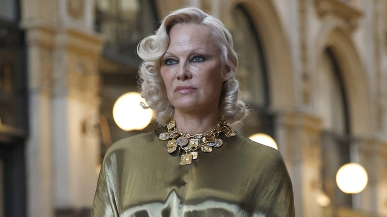 Pamela Anderson in Milan in 2026 wearing gold with dark eye makeup