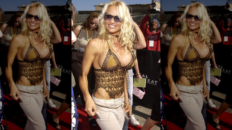 Pamela Anderson smiles wearing a crochet brown top and sunglasses