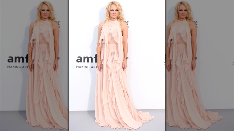 Pamela Anderson in a peach gown with long strips of fabric