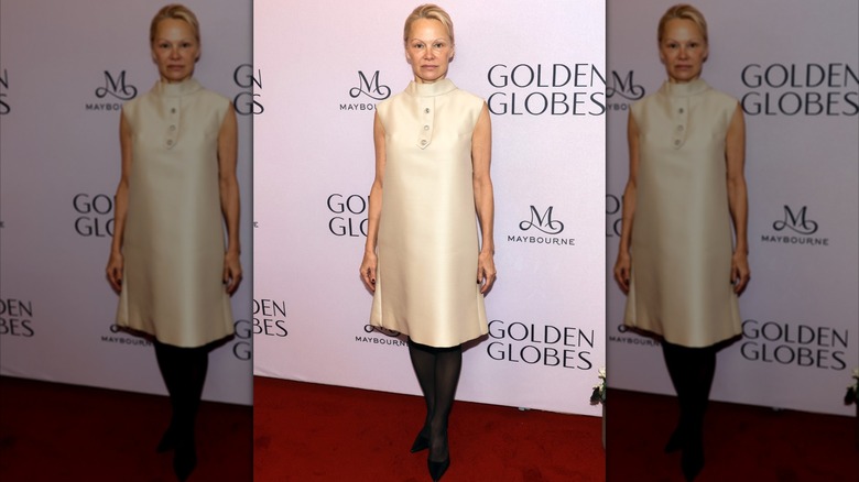 Pamela Anderson in a cream dress with black tights