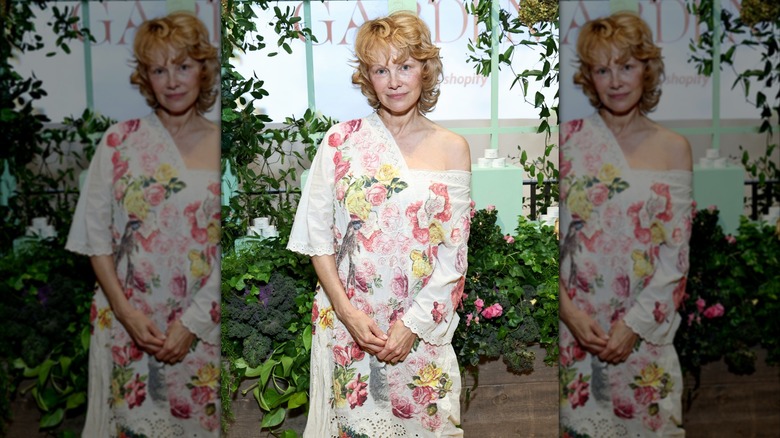 Pamela Anderson with strawberry blonde hair in a flower dress at an event