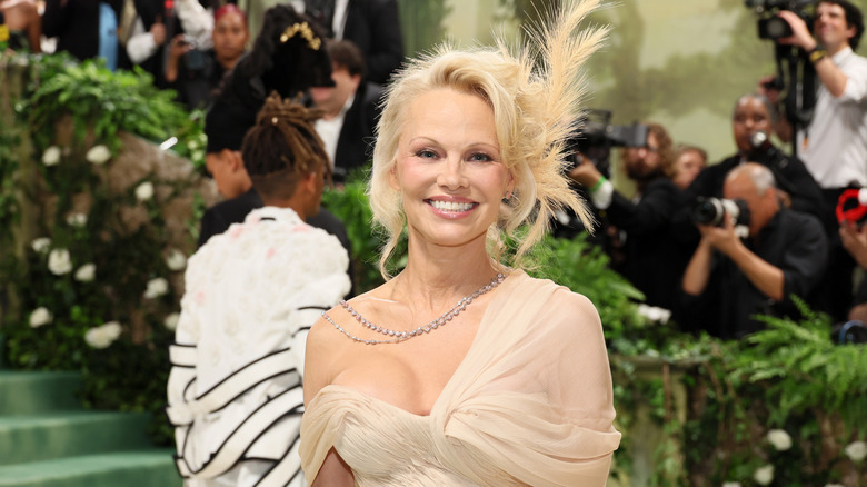 Pamela Anderson smiles on the red carpet in 2024